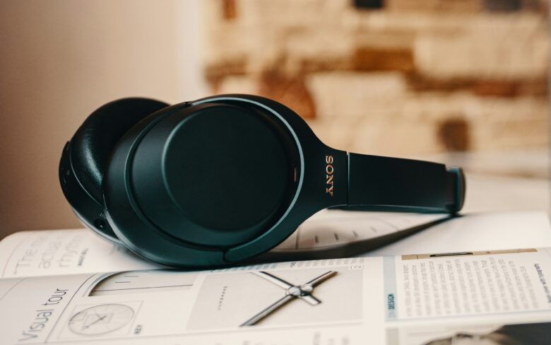 Auriculares inalámbricos Sony WH-1000X en color verde oscuro apoyados sobre documentación técnica impresa