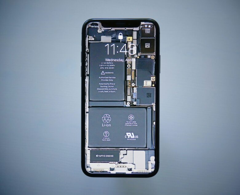 iPhone con fondo de pantalla de rayos X que muestra la batería y los componentes internos del dispositivo